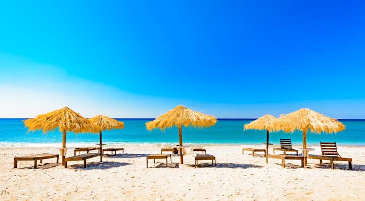 Photo of e beach with umbrellas and sunbeds, Pythagorio ,Greece, the island of Samos.
