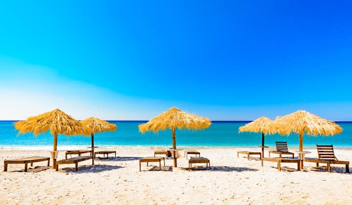 Photo of e beach with umbrellas and sunbeds, Pythagorio ,Greece, the island of Samos.
