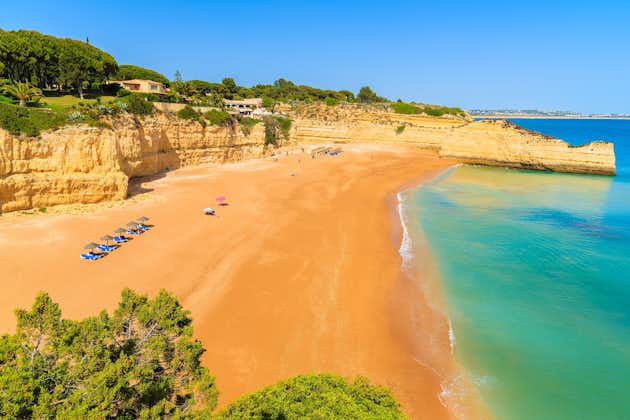 Photo of aerial view of beautiful sandy beach and turquoise sea in Armacao de Pera village, Algarve region, Portugal.