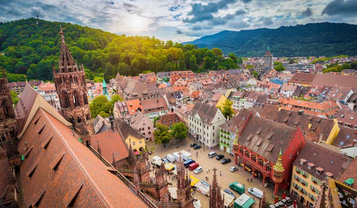 Photo of aerial view of the historic city center of Freiburg im Breisgau from famous old Freiburger Minster in beautiful evening light at sunset with blue sky and clouds in summer, Baden-Wurttemberg, Germany.