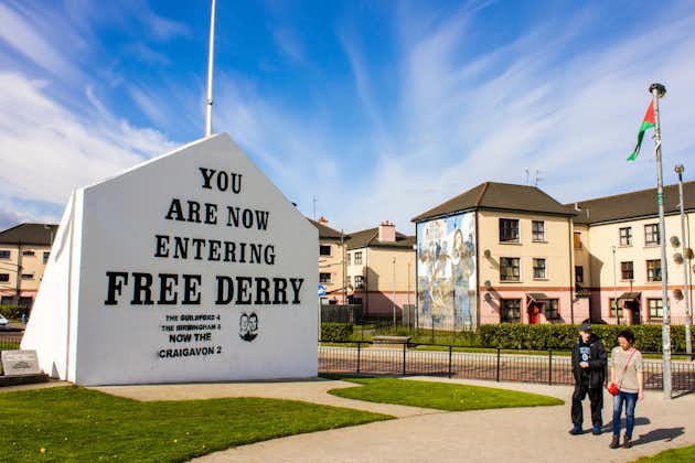 The 'You are Now Entering Free Derry' Corner in Londonderry, Northern Ireland, with two passersby.