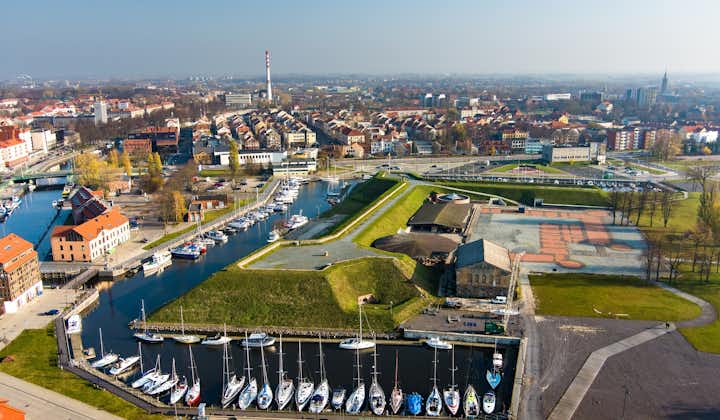 Aerial view of beautiful yachts by the pier in the yacht club in Klaipeda, Lithuania. Klaipeda old castle site. Autumn view of Dane river.