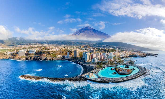 Photo of aerial view with Puerto de la Cruz, in background Teide volcano, Tenerife island, Spain.