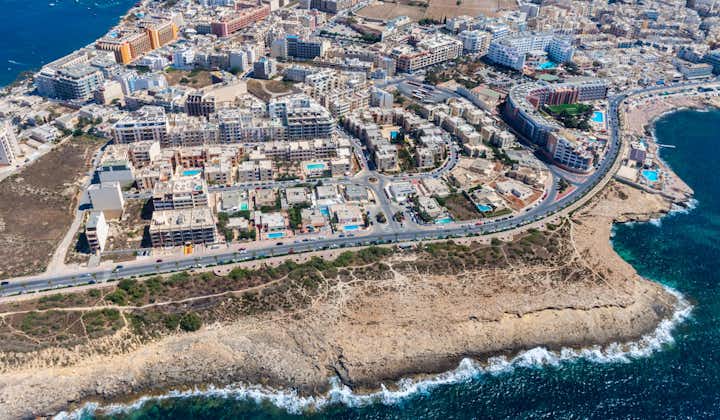 Photo of seaside cliffs, colorful houses and streets of Qawra town in St. Paul's Bay area in the Northern Region, Malta.