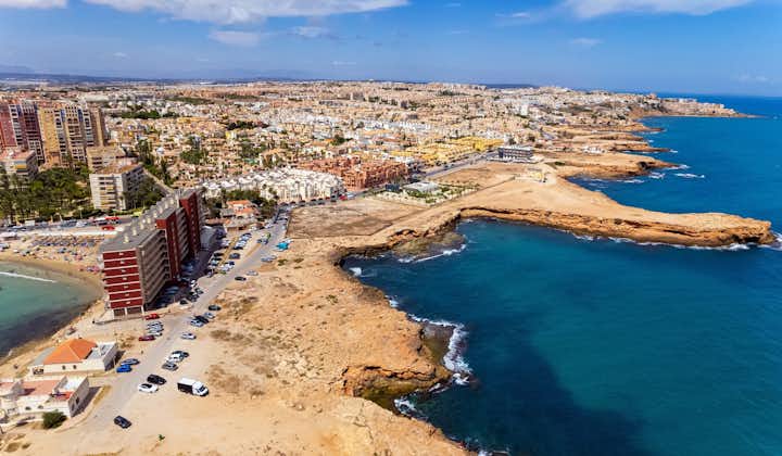 Aerial drone point of view rocky coastline of spanish tourist resort town of Torrevieja, Spain.