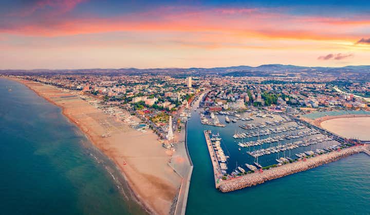 Photo of Panoramic summer view from flying drone of Libera Rimini public beach. Captivating evening scene of Italy, Europe. Colorful sunset on Adriatic coast. Vacation concept background.