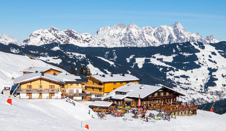 Photo of downhill slope and ski mountain hut with restaurant terrace in Saalbach Hinterglemm Leogang winter resort, Tirol, Austria.