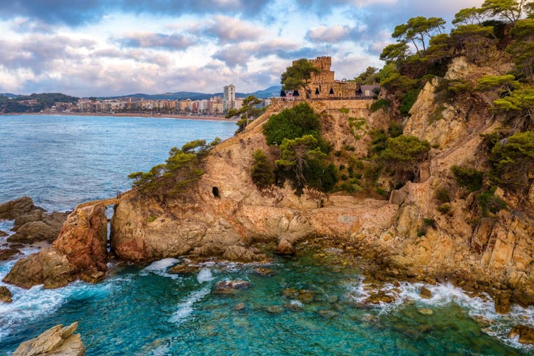 Colorful rocks on the Costa Brava coast in Lloret de Mar, a popular tourist resort on Mediterranean sea coast, Catalonia, Spain.