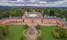 Photo of aerial view of Sychrov Castle with typical pink facade. Neo-Gothic style chateau with beautiful english style park, Czech Republic.