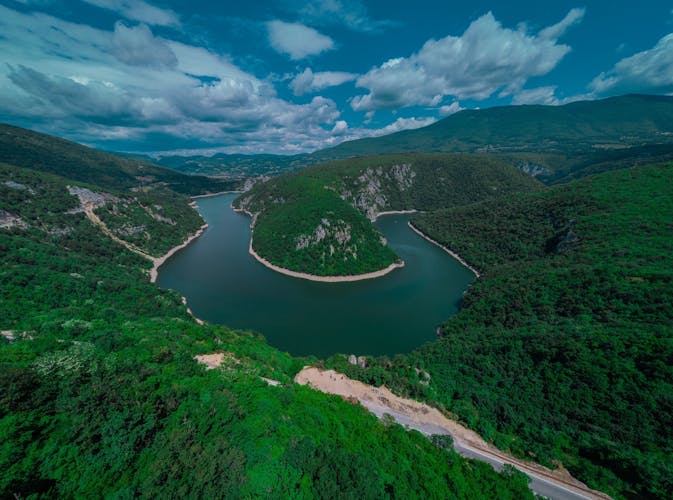 PHOTO OF VIEW OF Curve or meander on river Vrbas, drone panorama, close to Banja Luka in bosnia and hercegovina on a sunny morning with puffyy clouds.Curve or meander on river Vrbas, drone panorama, close to Banja Luka in bosnia and hercegovina on a sunny morning with puffyy clouds.