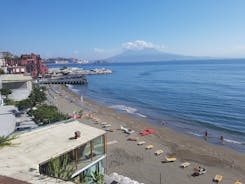 Naples, Italy. View of the Gulf of Naples from the Posillipo hill with Mount Vesuvius far in the background and some pine trees in foreground.