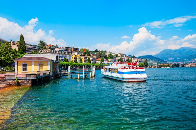 Photo of Tourist boat in Lugano lake and Lugano city in canton of Ticino in Switzerland.