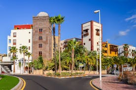 photo of aerial shot of Costa Adeje area, South Tenerife, Spain. Captured at golden hour, warm and vivid sunset colors. Luxury hotels, villas and restaurants behind the beach.