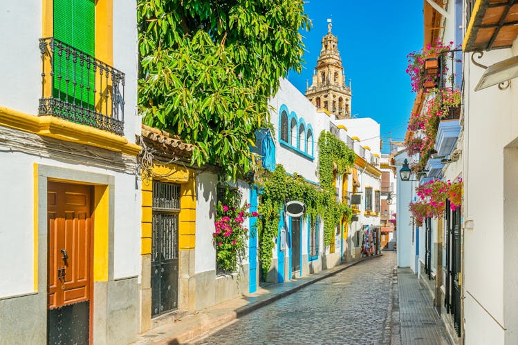 photo of view of Scenic sight in the picturesque Cordoba jewish quarter with the bell tower of the Mosque Cathedral. Andalusia, Spain.