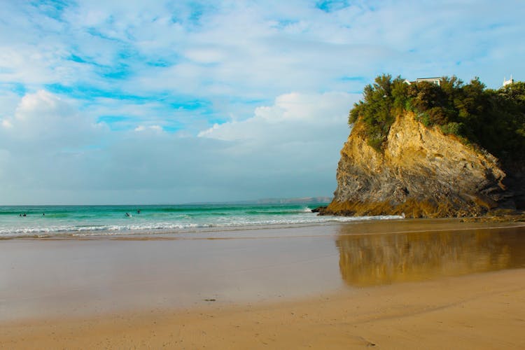 Photo of empty sandy beach and cliff at Newquay Beach Front, United Kingdom