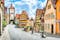 Photo of beautiful postcard view of the famous historic town of Rothenburg ob der Tauber on a sunny day with blue sky and clouds in summer, Franconia, Bavaria, Germany.