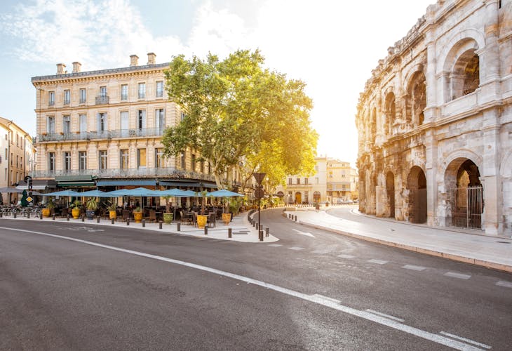 Photo of morning street view with roman amphitheater building in Nimes city on southern france.