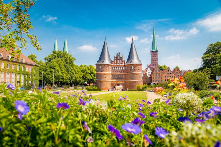 Classic postcard view of the historic town of Lübeck with famous Holstentor gate in summer, Schleswig-Holstein, northern Germany