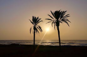 photo of aerial shot of Costa Adeje area, South Tenerife, Spain. Captured at golden hour, warm and vivid sunset colors. Luxury hotels, villas and restaurants behind the beach.