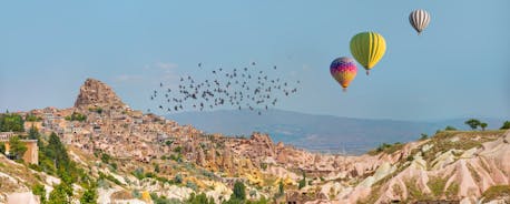 Hot air balloons flying over Uchisar Castle. Cappadocia. Nevsehir Province. Turkey.