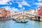 Famous buildings, gondolas and monuments by the Rialto Bridge of Venice on the Grand Canal, Italy.