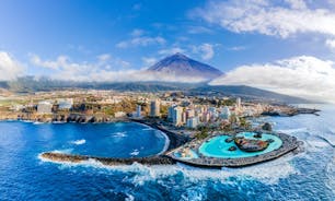 Photo of aerial view with Puerto de la Cruz, in background Teide volcano, Tenerife island, Spain.