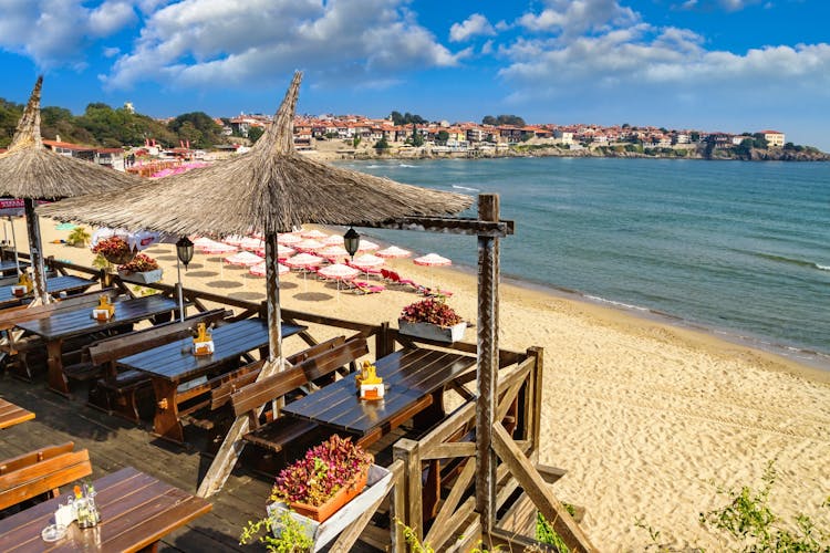 Seaside landscape - view of the cafe and the sandy beach with umbrellas and sun loungers in the town of Sozopol on the Black Sea coast in Bulgaria