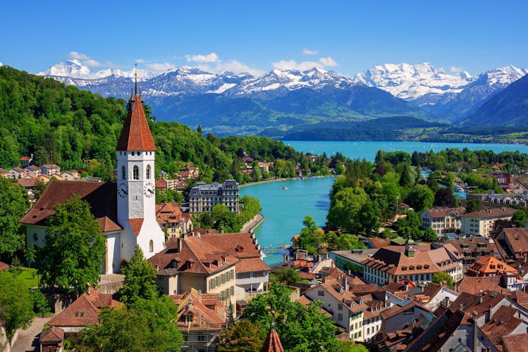 Photo of Historical Thun city with snow covered Bernese Highlands swiss Alps mountains in background, Bern, Switzerland.