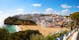 Photo of beautiful aerial view of the sandy beach surrounded by typical white houses in a sunny spring day, Carvoeiro, Lagoa, Algarve, Portugal.