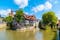 Photo of old town houses of Esslingen am Neckar city in summer with blue sky and sun next to Neckar river water, Germany.