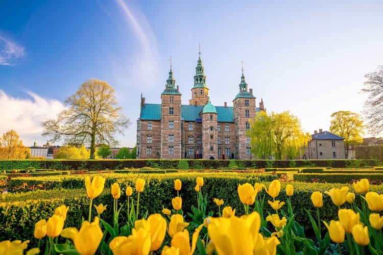Photo of Rosenborg Castle Gardens in Copenhagen, Denmark with blue sky.