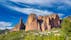 photo of a scenic view of the famous rock formations of Mallos de Riglos under wispy sky background in Las Peñas de Riglos, Spain.