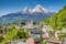 photo of historic town of Berchtesgaden with famous Watzmann mountain in the background on a sunny day with blue sky and clouds in springtime, National Park Berchtesgaden Land, Upper Bavaria, Germany.