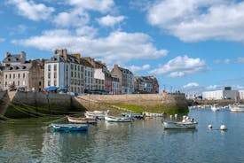 Photo of Vannes, beautiful city in Brittany, boats in the harbor, with typical houses and the cathedral in background, France.