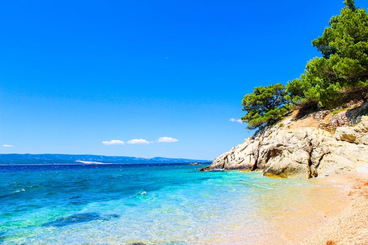 Photo of Laguna beautiful beach surrounded by rocks and forests, Pisak Split Dalmatia, Croatia.