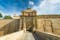 Photo of entrance bridge and gate to Mdina, a fortified medieval city in the Northern Region of Malta.