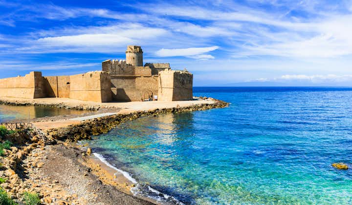 Photo of Le Castella Isola di Capo Rizzuto amazing castle and beautiful beach with blue sky, Calabria, Italy.