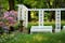 photo of view of Scenery in a Park in spring: a white pergola, bench an flowering Rhododendrons on the left (Knoops Park , Bremen, Germany