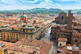 Photo of Italy Piazza Maggiore in Bologna old town tower of town hall with big clock and blue sky on background, antique buildings terracotta galleries.