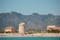photo of Torre del Marenyet seen from the water with the mountains in the background in Cullera, Valencia, Alicante, Spain.