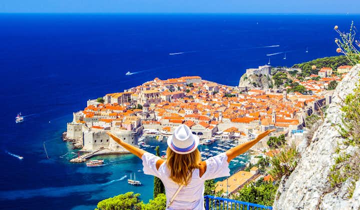 Photo of woman enjoys view of Dalmatian Coast of Adriatic Sea in Dubrovnik.