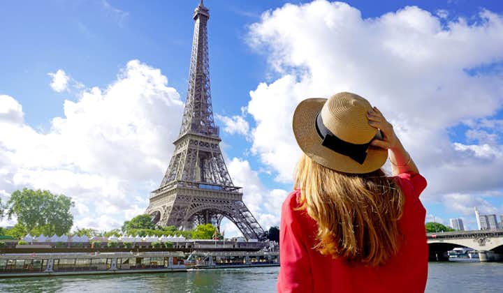 Photo of back view of beautiful tourist girl enjoying view of Eiffel Tower in Paris, France. 