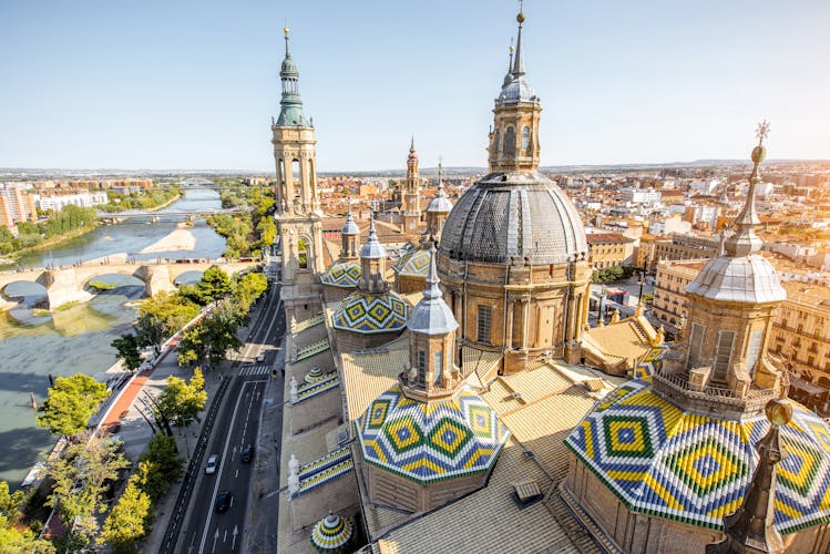 Photo of aerial cityscape view on the roofs and spires of basilica of Our Lady in Zaragoza city in Spain.