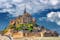 Photo of beautiful panoramic view of famous Le Mont Saint-Michel tidal island with blue sky, northern France.