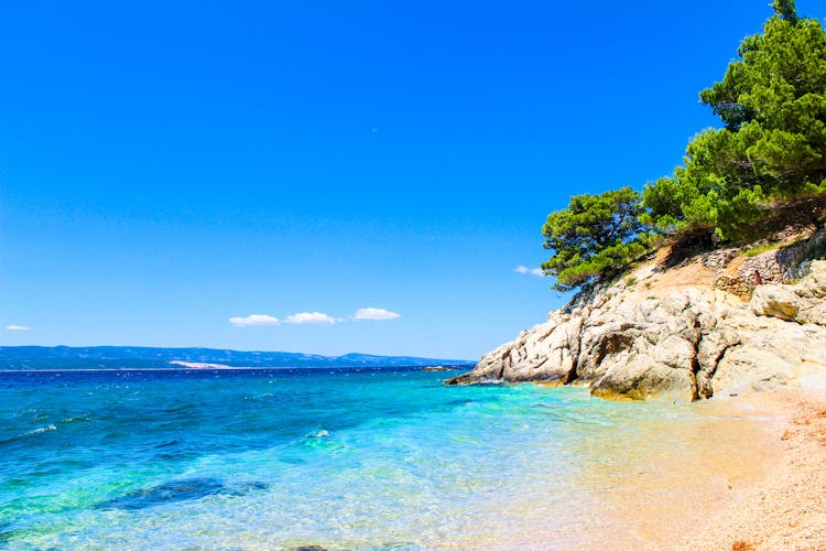 Photo of Laguna beautiful beach surrounded by rocks and forests, Pisak Split Dalmatia, Croatia.